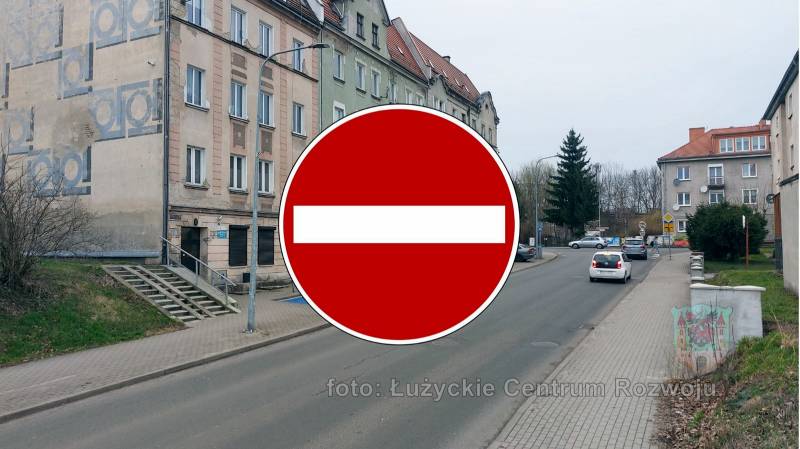 znak drogowy-zakaz ruchu, w tle ulica, z lewej kamienica